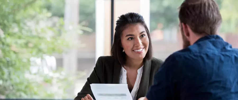 Une femme et un homme discutent à un bureau